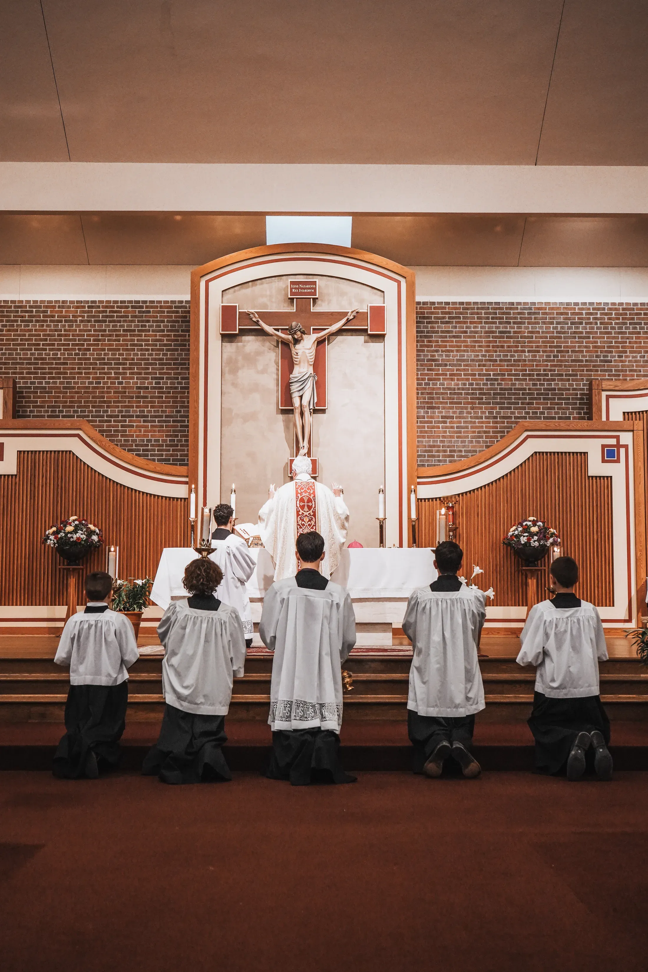 Sacerdote y monaguillos ante el crucifijo y el altar